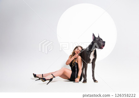 Portrait of beautiful sexy model in the black dress with german dogge on a white background 126358222
