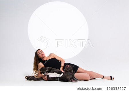 Portrait of beautiful sexy model in the black dress with german dogge on a white background 126358227