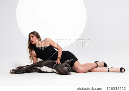 Portrait of beautiful sexy model in the black dress with german dogge on a white background 126358232