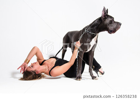 Portrait of beautiful slender model dressed in the black suit with german dogge on a white background 126358238