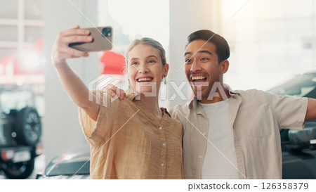 Couple, excited and photography with selfie in car dealership, celebration and picture of new motor. Showroom, man and woman with hug for vehicle purchase, auto transport and memory for social media Couple, excited and photography with selfie in car dealership, celebration and picture of new motor. Showroom, man and woman with hug for vehicle purchase, auto transport and memory for social media 126358379