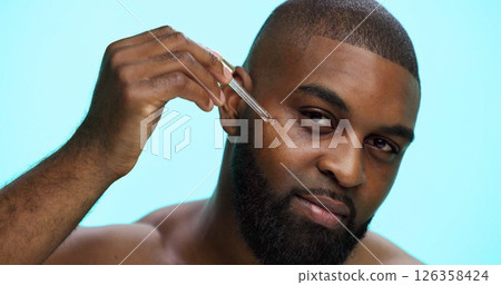 Portrait, serum and black man in studio, skincare and dermatology on blue background. African person, facial cosmetics or model with dropper, hyaluronic acid and oil with collagen, glow or anti aging Portrait, serum and black man in studio, skincare and dermatology on blue background. African person, facial cosmetics or model with dropper, hyaluronic acid and oil with collagen, glow or anti aging 126358424