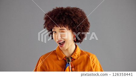 Woman, smile and fashion with wink in studio portrait, flirt and playful with afro by background. Girl, model and happy with eye emoji, space or secret for retro style, confidence and pride in Brazil Woman, smile and fashion with wink in studio portrait, flirt and playful with afro by background. Girl, model and happy with eye emoji, space or secret for retro style, confidence and pride in Brazil 126358441