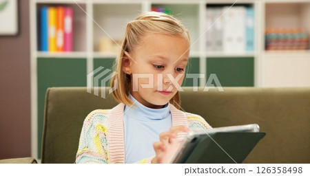Girl, reading or sofa with tablet for elearning, education or lesson at private elementary school. Child, kid or student with technology or app on couch for childhood development, ebook or story time 126358498