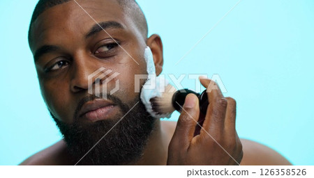 Brush, foam and shaving with black man in studio, cosmetic care and product with skincare on blue background. Space, cream or facial maintenance for hair removal, beauty or grooming for hygiene Brush, foam and shaving with black man in studio, cosmetic care and product with skincare on blue background. Space, cream or facial maintenance for hair removal, beauty or grooming for hygiene 126358526