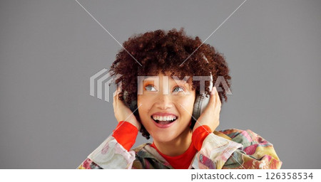 Headphones, thinking and woman in studio, listening to music and sound on grey background. Person, mockup space or happy model with confidence, fashion or headset with audio, streaming radio or smile 126358534