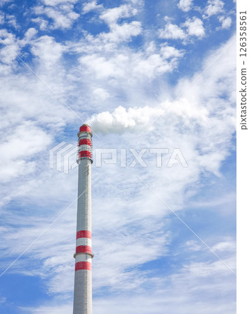 Industrial chimney emitting smoke into blue sky with clouds in Prague 126358561