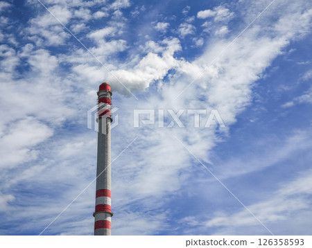 Industrial chimney emitting smoke into cloudy blue sky in Prague 126358593