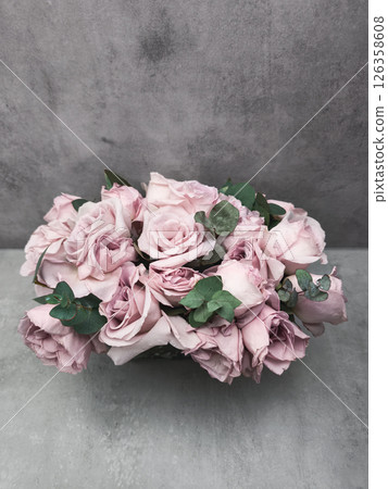 Delicate pink roses and eucalyptus compose a stunning bridal bouquet on a textured gray background wallpaper copy space 126358608