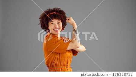 Portrait, flexing arms and woman with victory, power or win with confidence on grey background. Vintage clothes, person or model with space, retro outfit or female empowerment with smile or strong 126358732