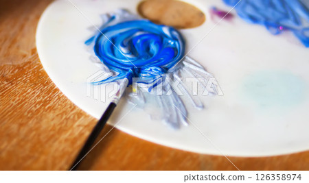 Close-up of a smeared bright acrylic paints on a white plastic palette. 126358974