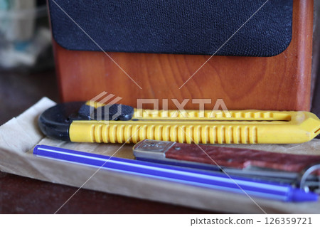 A stationery knife is lying near the speaker. A stationery knife is lying near the speaker. 126359721