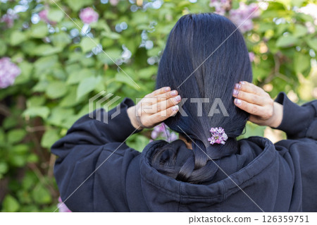 Woman with flowers in the hair. Sprig lilac flowers. 126359751