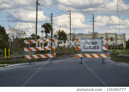 Yellow protective barrier at street construction site. Warning road sign about utility work Yellow protective barrier at street construction site. Warning road sign about utility work 126360777
