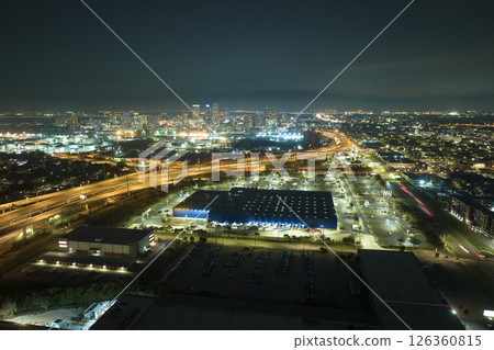 View from above of many parked cars on illuminaded parking lot at night in front of a superstore. Place for vehicles in front of a shopping mall center View from above of many parked cars on illuminaded parking lot at night in front of a superstore. Place for vehicles in front of a shopping mall center 126360815