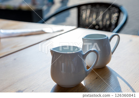 Two white cups of coffee on a table of outdoor cafe. 126360841