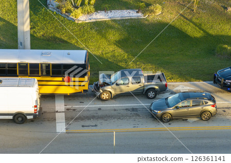 Traffic accident on American street in Florida. First responders helping victims of school bus and car crash on road in USA. Aerial view of emergency services responding to accident site 126361141