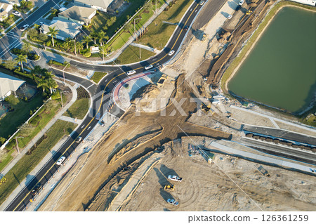 Roundabout intersection construction in North Port, Florida. Development of American road circle with moving traffic cars. Urban circular transportation crossroads 126361259