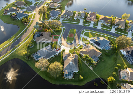 Residential homes at sunset in suburban sprawl development in North Port, Florida. Low-density private houses in rural suburbs. Housing market in the USA Residential homes at sunset in suburban sprawl development in North Port, Florida. Low-density private houses in rural suburbs. Housing market in the USA 126361279