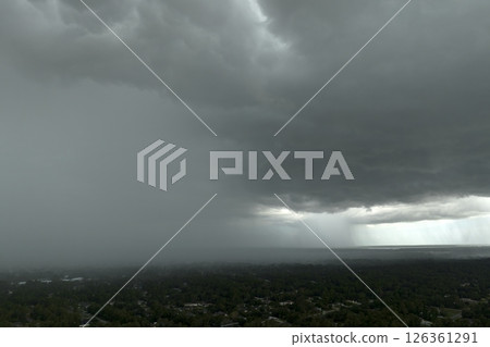 Rainstorm shower over Florida rural town in humid summer season. Rain water pouring down from stormy clouds 126361291