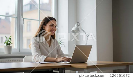 Happy businesswoman working on laptop 126361672