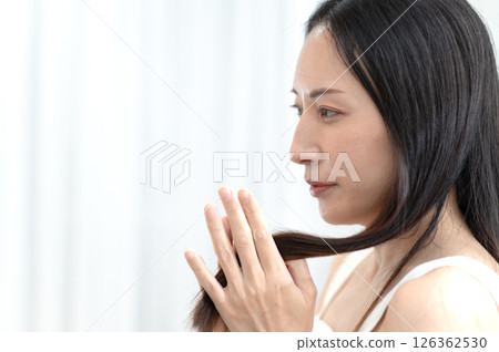 一個女人撫摸她的頭髮 一個女人撫摸她的頭髮 126362530