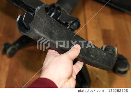 Man holding broken leg of office chair: workplace trouble, defective chair 126362568