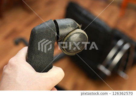 Man holding broken leg of office chair: workplace trouble, defective chair Man holding broken leg of office chair: workplace trouble, defective chair 126362570