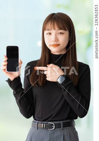 Woman/businesswoman pointing at smartphone Woman/businesswoman pointing at smartphone 126362853