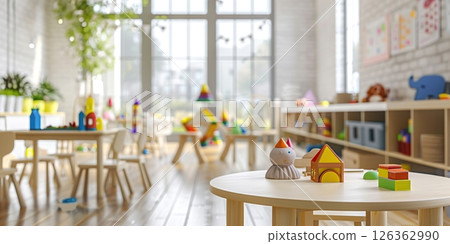 Interior Of Modern Kindergarten Classroom. Stylish playroom interior with shelving unit and different soft toys. Children's playroom. Plastic colorful educational blocks toys, white tables and chairs 126362990