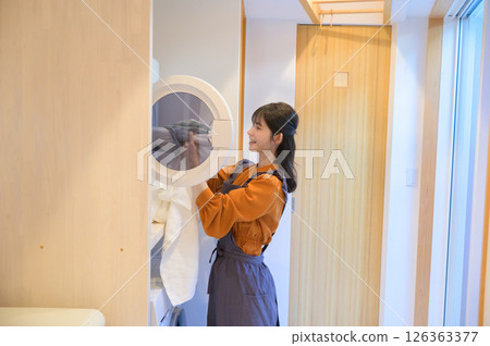 一位微笑的日本婦女正在洗衣服 126363377