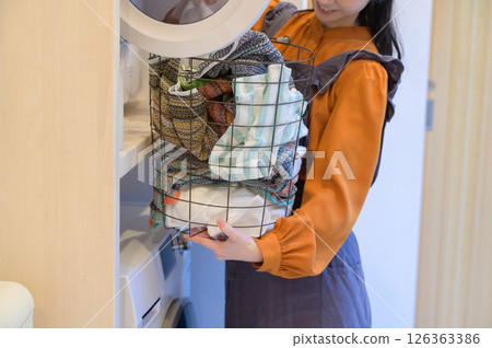 一位微笑的日本婦女正在洗衣服 一位微笑的日本婦女正在洗衣服 126363386