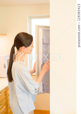 A worried Japanese woman looking at the refrigerator 126363423