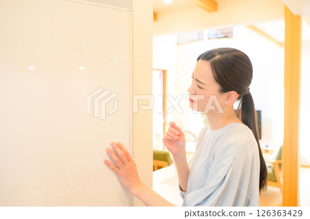 一位憂心忡忡的日本女性看著冰箱 一位憂心忡忡的日本女性看著冰箱 126363429