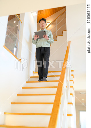 Japanese man in work clothes inspecting home facilities Japanese man in work clothes inspecting home facilities 126363455