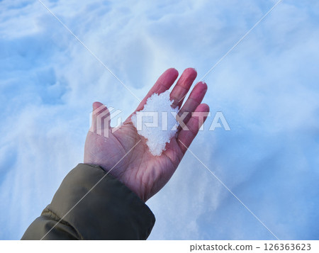 一個人的手在冬日田野裡觸摸著雪 一個人的手在冬日田野裡觸摸著雪 126363623