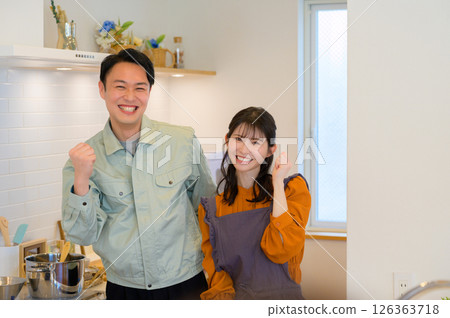 A Japanese man and a housewife in work clothes standing side by side in the kitchen A Japanese man and a housewife in work clothes standing side by side in the kitchen 126363718