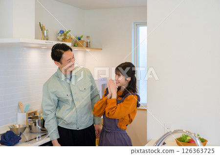 A Japanese man and a housewife in work clothes standing side by side in the kitchen A Japanese man and a housewife in work clothes standing side by side in the kitchen 126363725