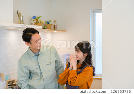 一位日本男子和一位身著工作服的家庭主婦並肩站在廚房裡 一位日本男子和一位身著工作服的家庭主婦並肩站在廚房裡 126363726