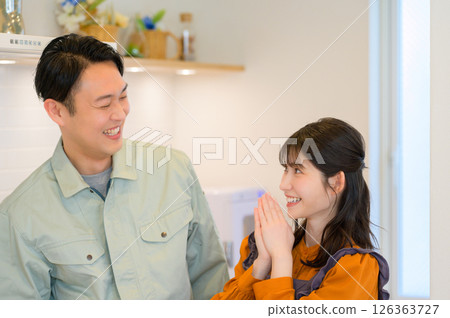一位日本男子和一位身著工作服的家庭主婦並肩站在廚房裡 一位日本男子和一位身著工作服的家庭主婦並肩站在廚房裡 126363727