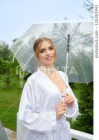 Young woman with transparent umbrella in garden Young woman with transparent umbrella in garden 126363941
