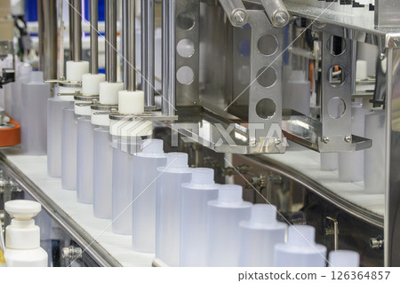 The empty healthcare bottles on the conveyor belt for filling process. 126364857