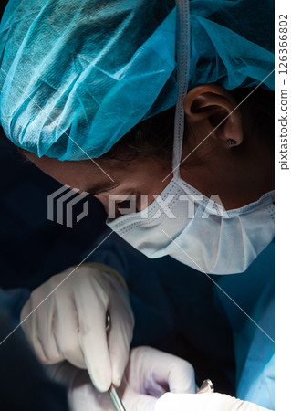 Female doctor performing a surgery. Surgery and insurance concept. 126366802