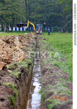trench for laying cables and pipes. excavator performs excavation work. trench for laying cables and pipes. excavator performs excavation work. 126366844