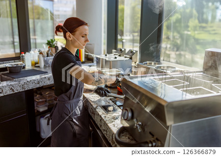 An exceptionally skilled barista at a vibrant, modern coffee shop, serving artisan beverages An exceptionally skilled barista at a vibrant, modern coffee shop, serving artisan beverages 126366879