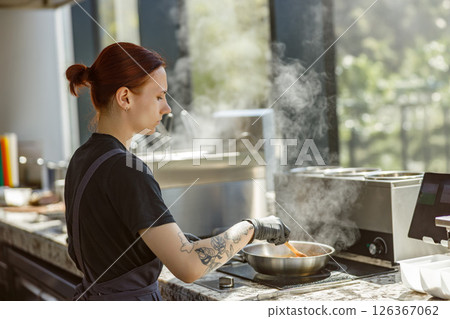 A Professional Chef is Preparing an Exquisite Gourmet Dish in a Modern Kitchen Space A Professional Chef is Preparing an Exquisite Gourmet Dish in a Modern Kitchen Space 126367062