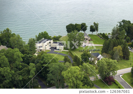 Private residential houses in lakeside suburban sprawl area in Rochester, New York. Upscale suburban homes with large backyard and green grassy lawn in summer season Private residential houses in lakeside suburban sprawl area in Rochester, New York. Upscale suburban homes with large backyard and green grassy lawn in summer season 126367081