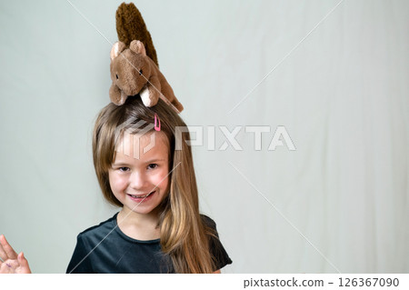 Pretty child girl playing with her teddy bear toy. 126367090