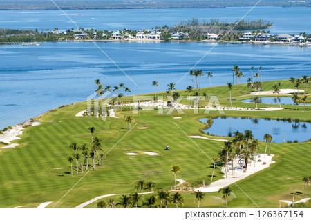 Oceanfront golf course in sunny Florida. Outdoor sport grounds with green grass lawns in Boca Grande, small town on Gasparilla Island 126367154