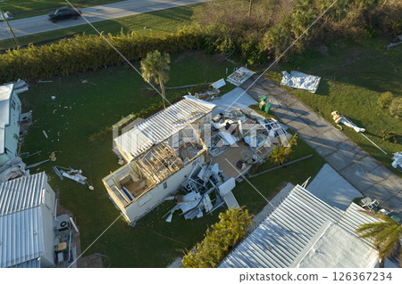 Hurricane strong wind destroyed suburban house roofs in Florida mobile home residential area. Consequences of natural disaster Hurricane strong wind destroyed suburban house roofs in Florida mobile home residential area. Consequences of natural disaster 126367234